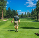 Blog Image: Back view of a golf player looking at the distance after his shot to support the stroke play blog